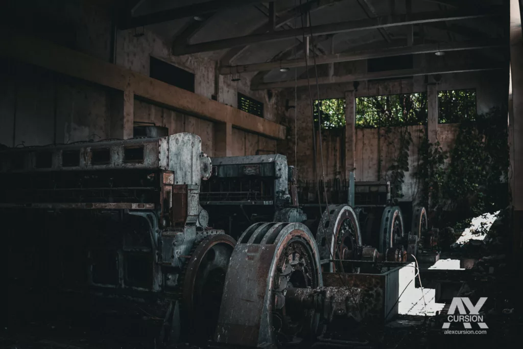 Ligne d'anciens groupes électrogènes massifs dans la nef d'une centrale abandonnée