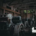 Ligne d'anciens groupes électrogènes massifs dans la nef d'une centrale abandonnée