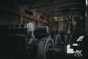 Ligne d'anciens groupes électrogènes massifs dans la nef d'une centrale abandonnée